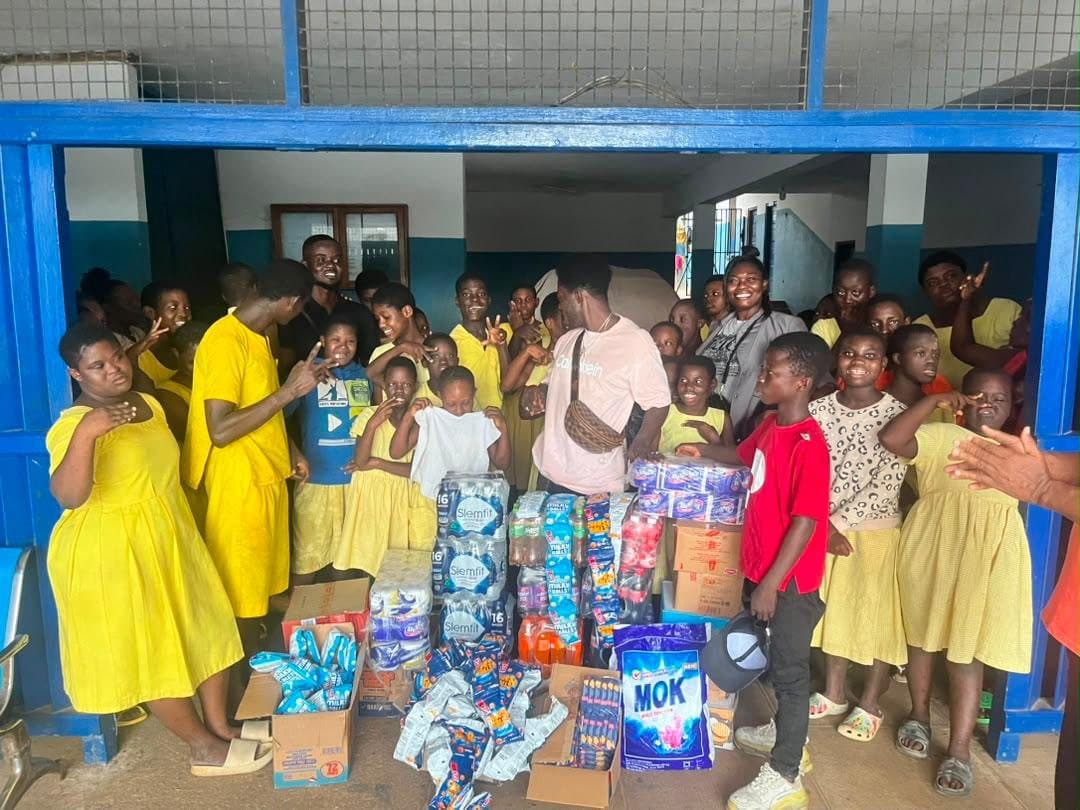 Pupils in yellow uniforms with donated food and supplies
