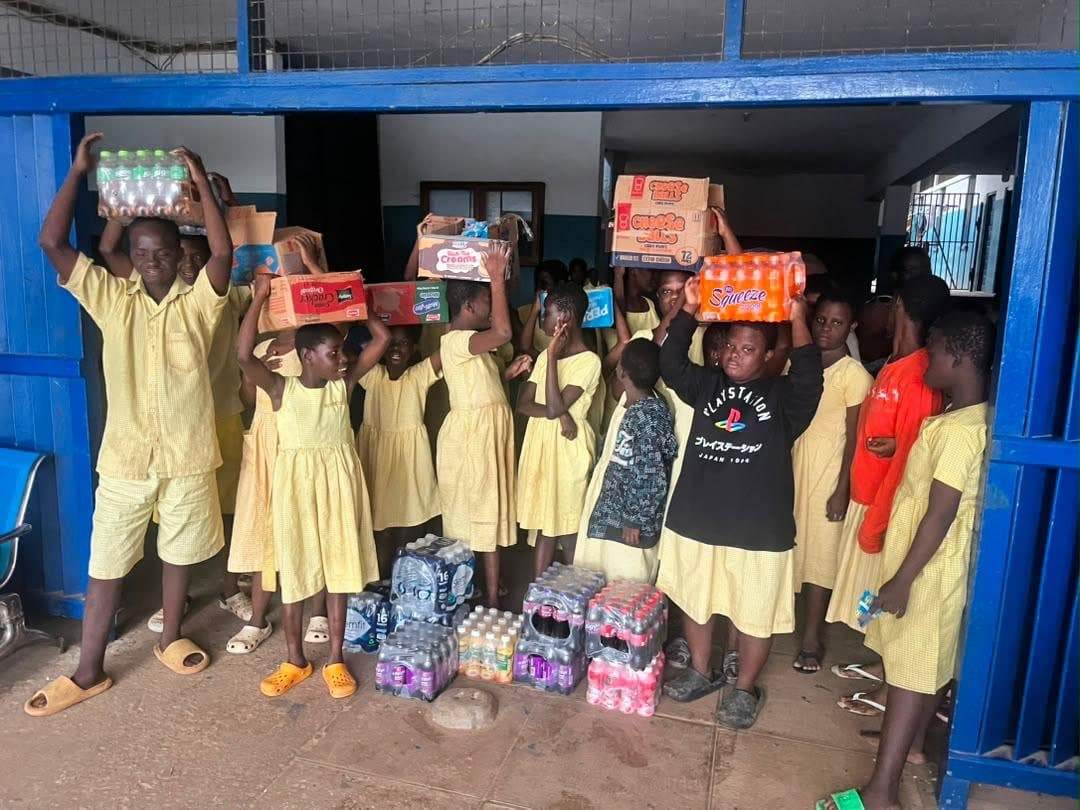 Pupils carrying boxes of donated supplies on their heads