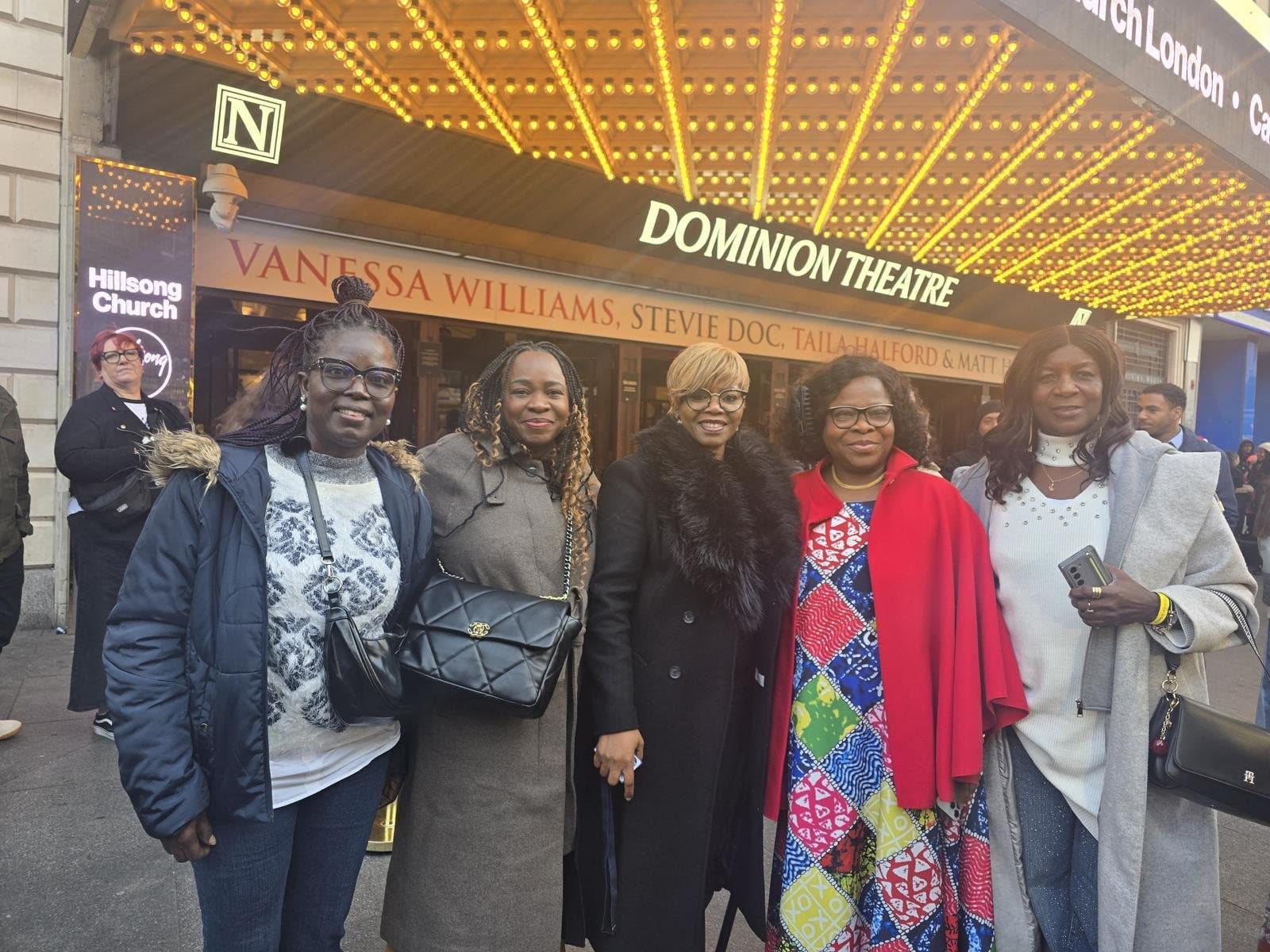 Foundation members smiling together under the theatre lights
